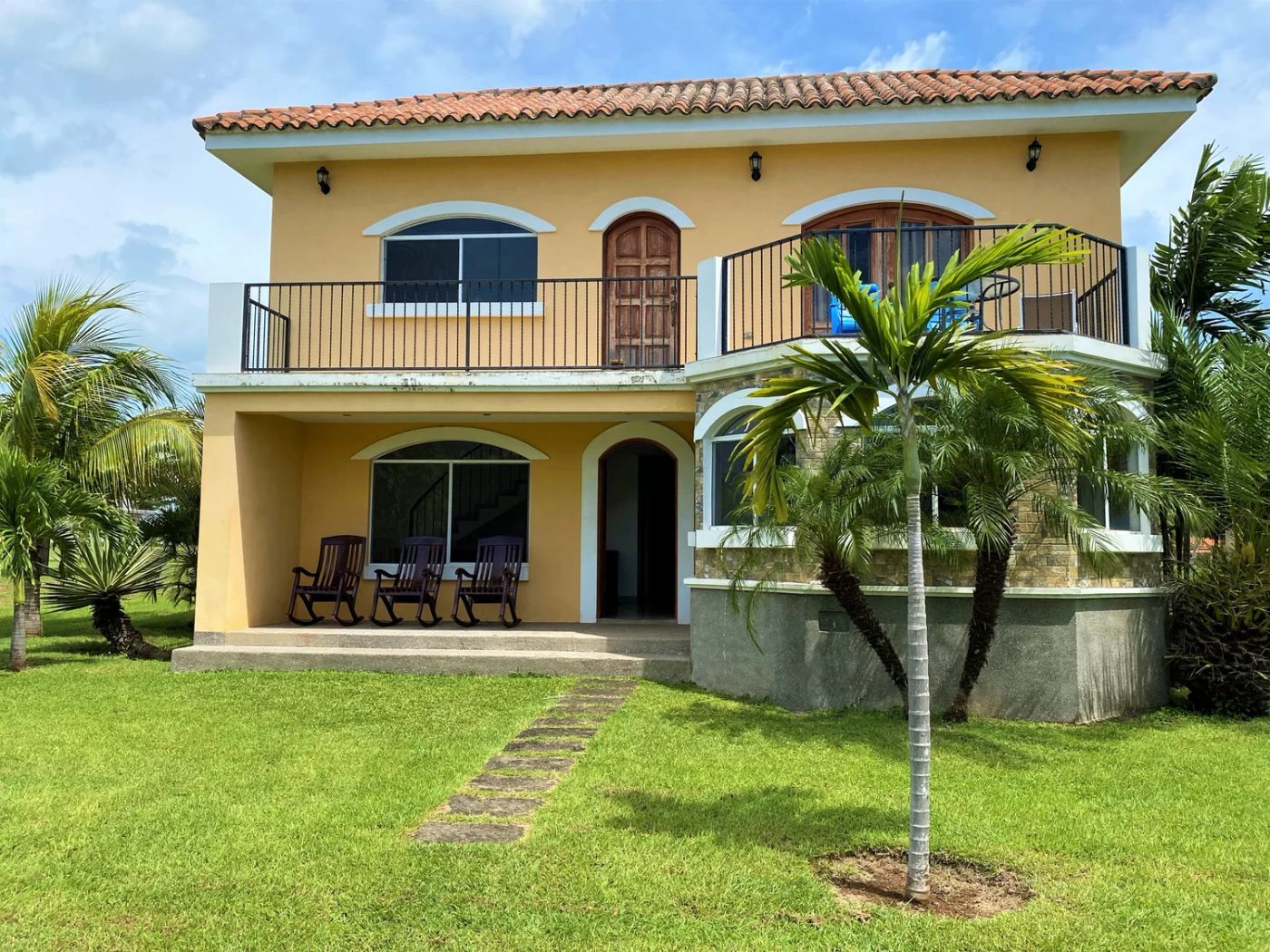 Casa Charros two-story yellow home with red tile roof